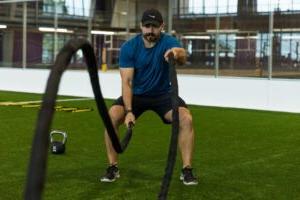 A man exercises with ropes.